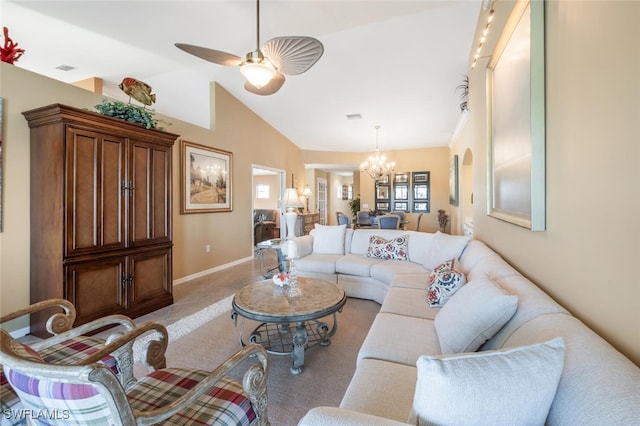 living room featuring ceiling fan with notable chandelier, baseboards, and vaulted ceiling