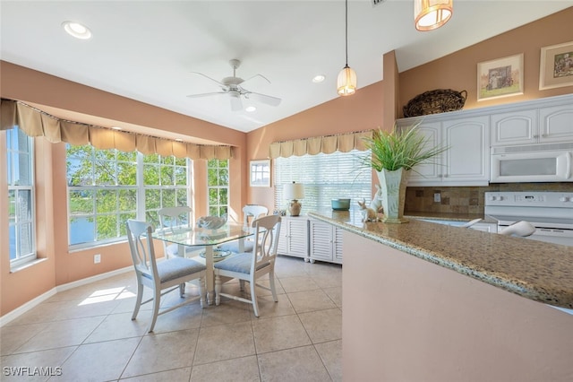 dining room with vaulted ceiling, light tile patterned floors, recessed lighting, and baseboards