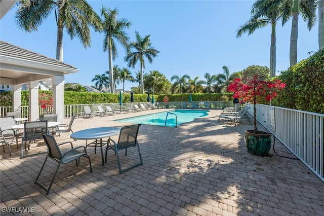 pool with a patio area and fence