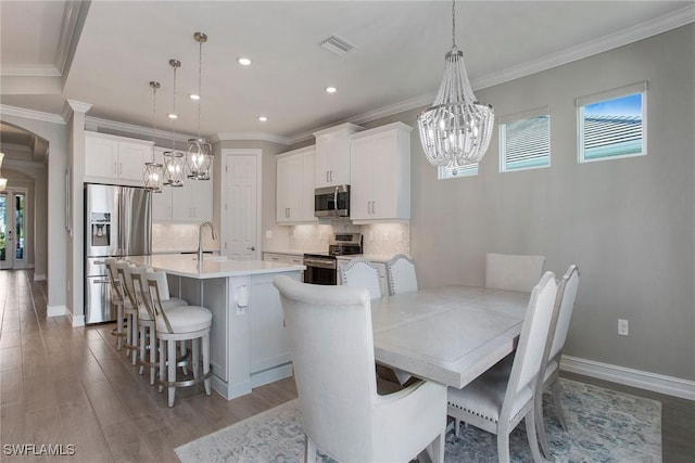 dining space featuring a wealth of natural light, visible vents, arched walkways, and a chandelier