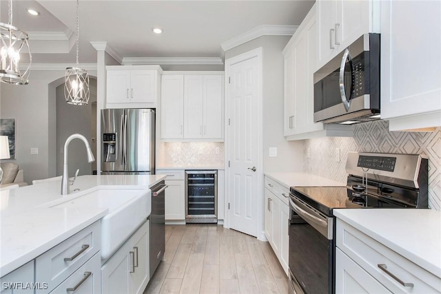 kitchen with a sink, white cabinetry, stainless steel appliances, wine cooler, and light countertops