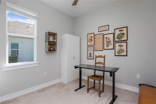 office featuring baseboards, light colored carpet, and ceiling fan