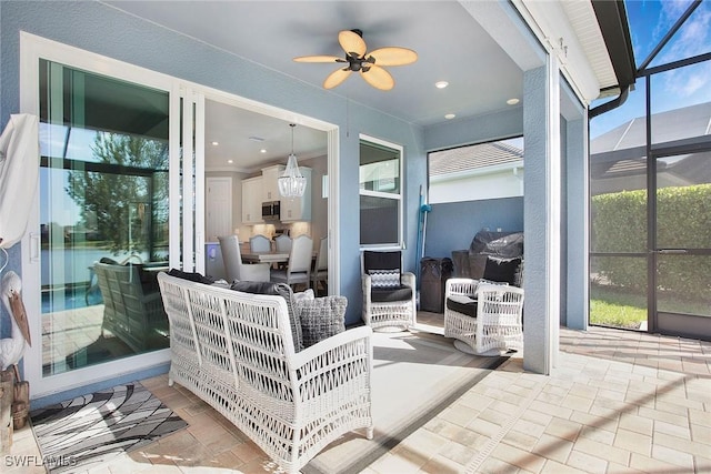 sunroom / solarium featuring a ceiling fan