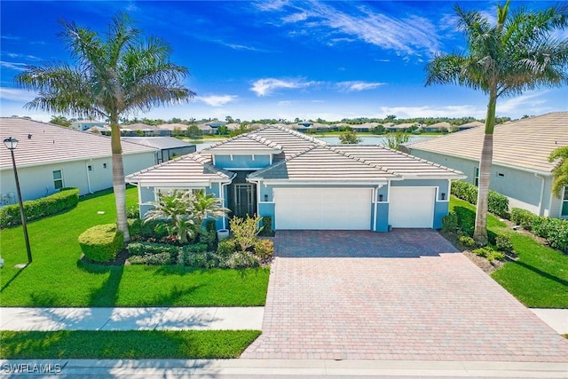 14597 Kelson Cir, Naples, FL 34114 - view of front facade with stucco siding, decorative driveway, a front yard, a garage, and a tiled roof