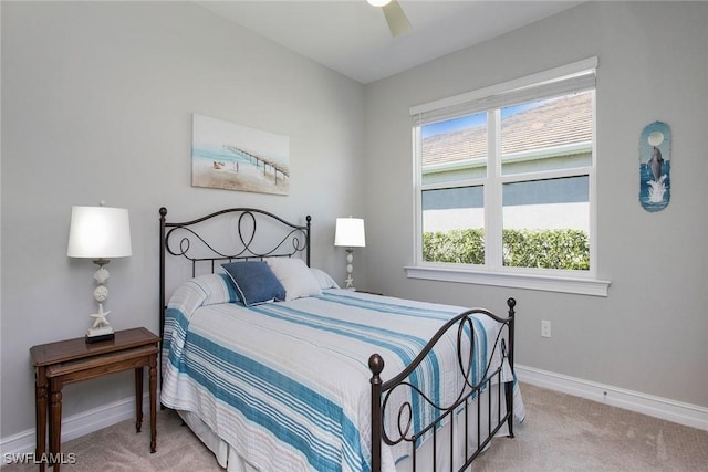 bedroom featuring baseboards, light carpet, and a ceiling fan