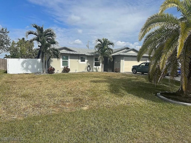 ranch-style house featuring an attached garage, fence, a front lawn, and stucco siding