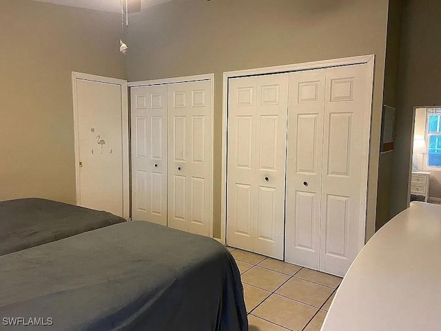 bedroom featuring multiple closets and light tile patterned floors