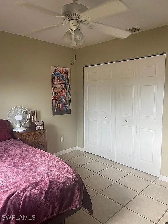 tiled bedroom with visible vents, ceiling fan, and baseboards