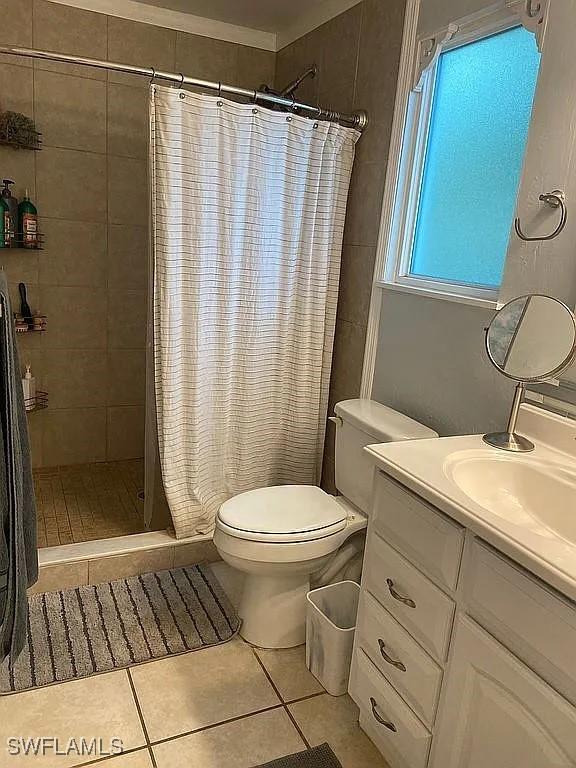 full bathroom with vanity, tile patterned flooring, toilet, and a shower stall