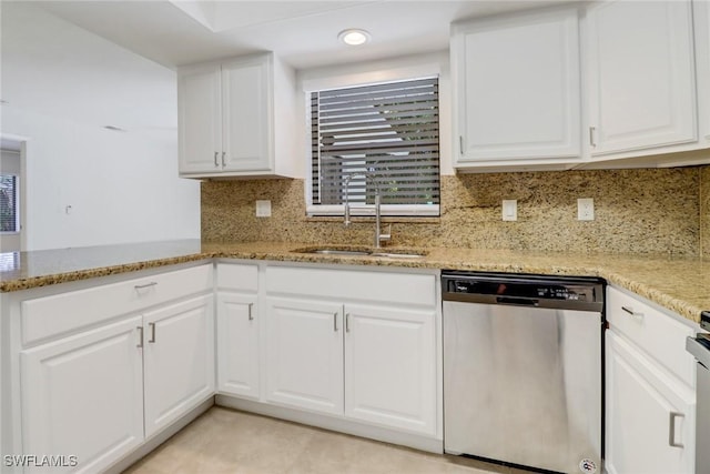 kitchen featuring a sink, light stone countertops, backsplash, and stainless steel dishwasher