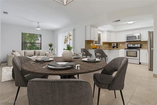 dining room featuring light tile patterned floors, visible vents, and a ceiling fan