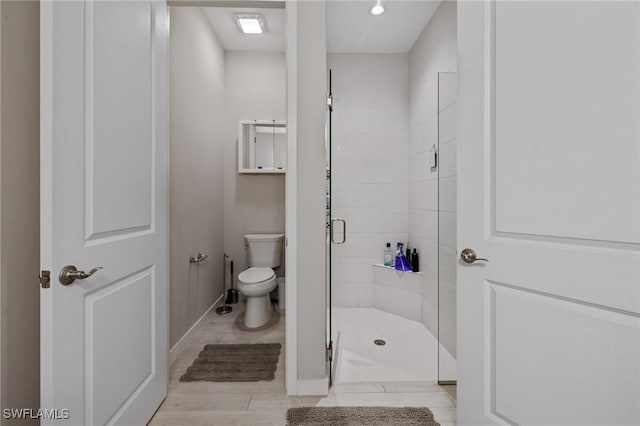 full bathroom featuring toilet, a stall shower, and baseboards