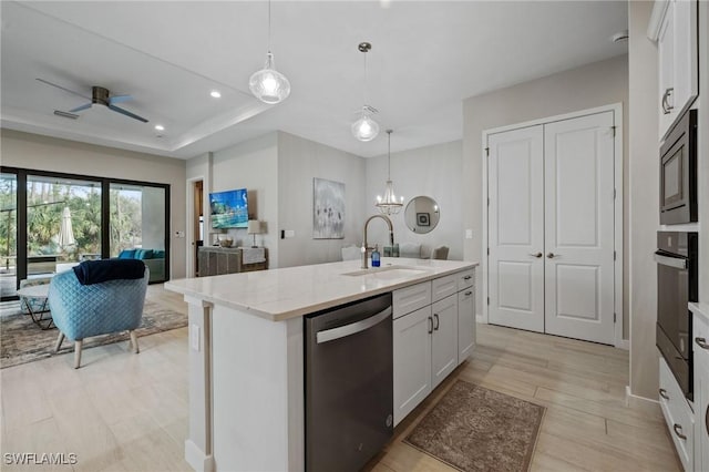 kitchen with open floor plan, white cabinets, a sink, built in microwave, and dishwasher