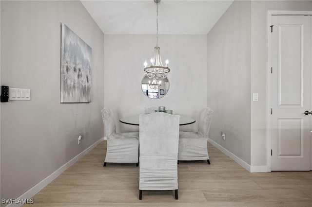 dining area with a notable chandelier, baseboards, and wood finished floors