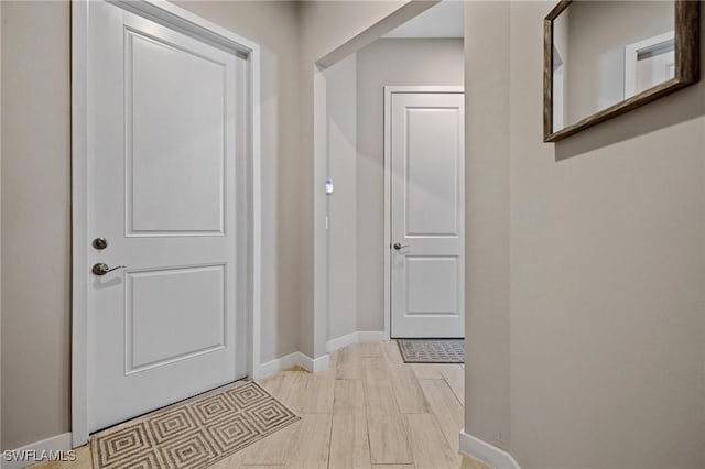 interior space featuring light wood-type flooring and baseboards