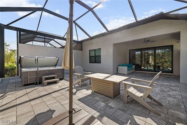 view of patio featuring a lanai, a hot tub, an outdoor living space, and a ceiling fan