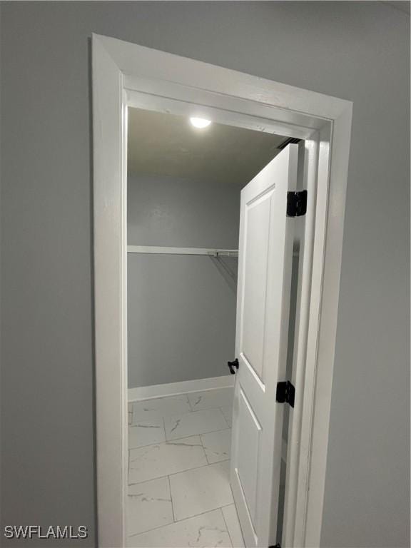 spacious closet with marble finish floor