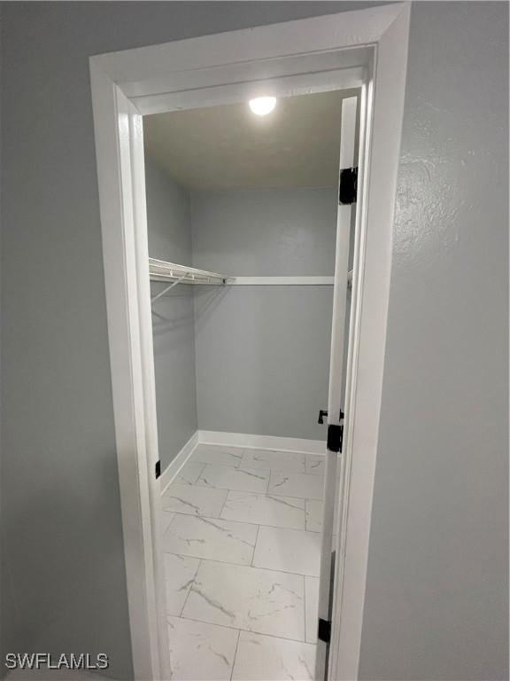 spacious closet featuring marble finish floor