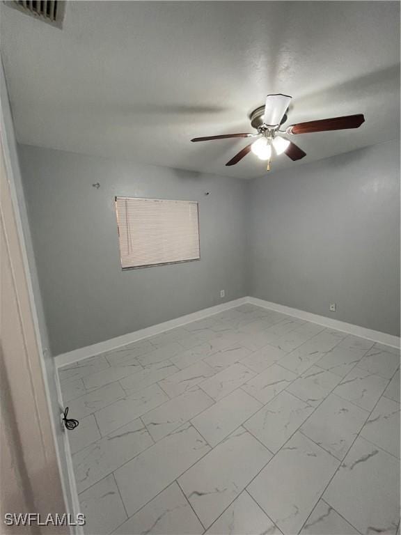 unfurnished room featuring visible vents, marble finish floor, baseboards, and ceiling fan