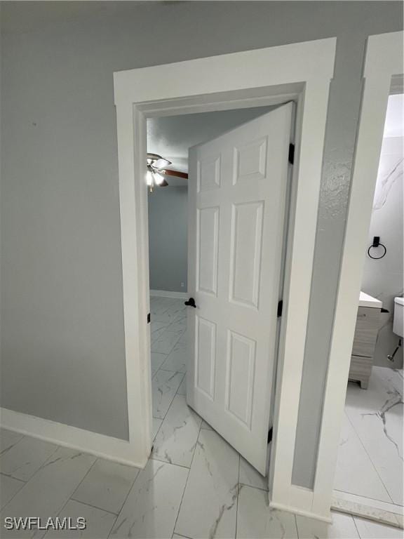 corridor featuring baseboards and marble finish floor