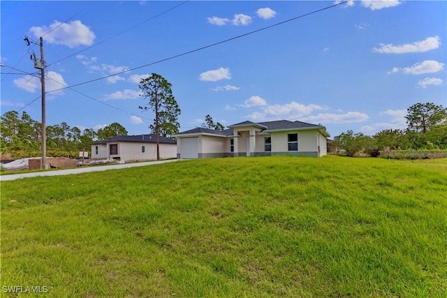 view of front of home featuring a garage, stucco siding, driveway, and a front yard