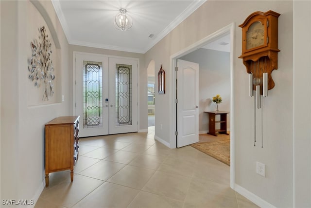 entrance foyer with french doors, arched walkways, light tile patterned flooring, crown molding, and baseboards