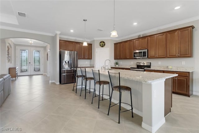 kitchen with visible vents, a kitchen bar, french doors, arched walkways, and appliances with stainless steel finishes