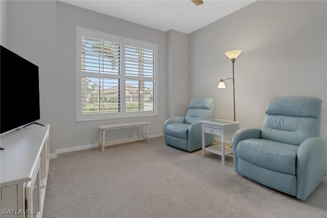 living area featuring baseboards and carpet