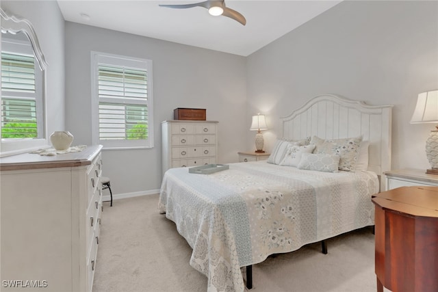 bedroom featuring ceiling fan, baseboards, and light carpet