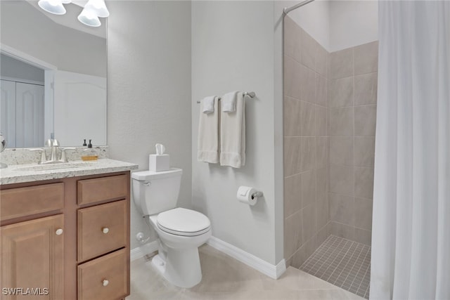 full bath featuring a tile shower, toilet, vanity, and baseboards