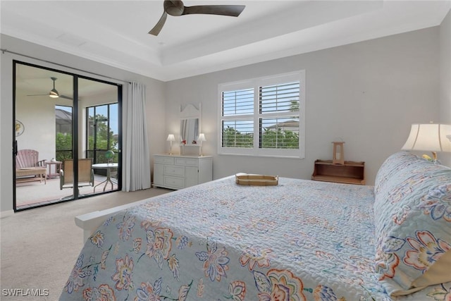 bedroom with access to exterior, carpet, a tray ceiling, ornamental molding, and a ceiling fan