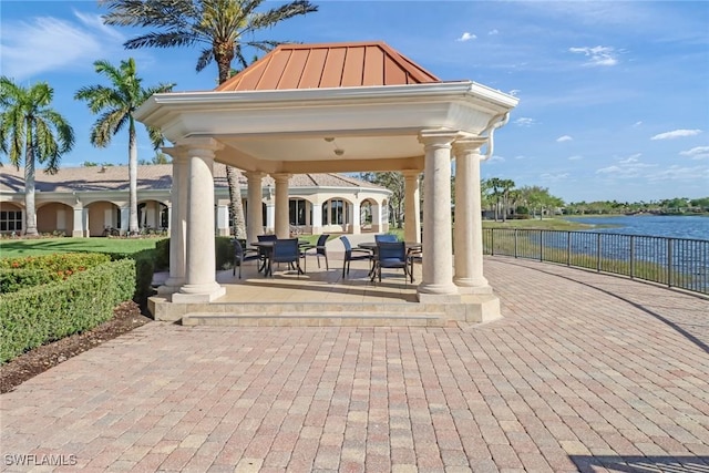 surrounding community with a water view, a patio area, fence, and a gazebo