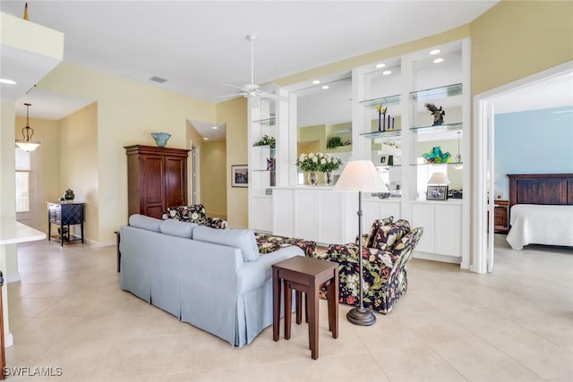 living area featuring built in shelves, visible vents, a ceiling fan, and recessed lighting