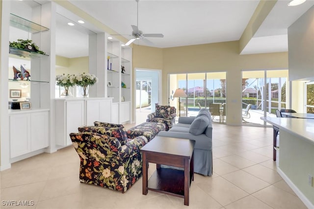 living area with light tile patterned floors, ceiling fan, and built in shelves