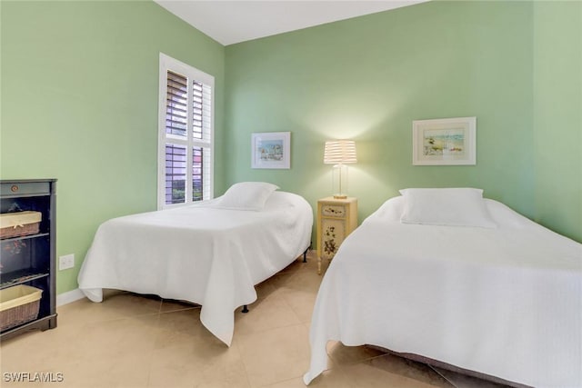 bedroom with light tile patterned floors and baseboards