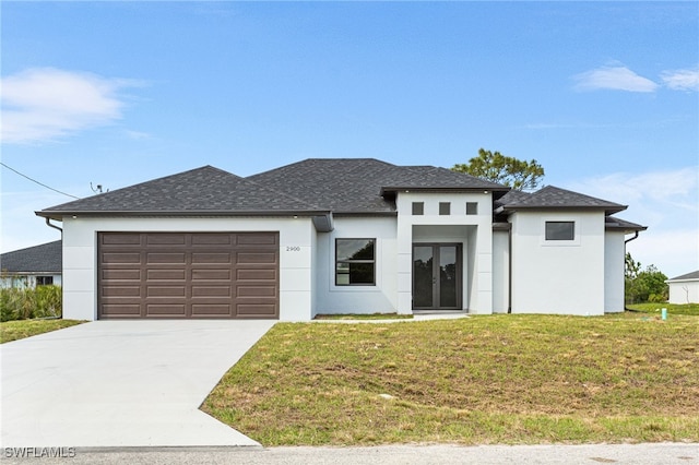 prairie-style home featuring french doors, a front lawn, an attached garage, and stucco siding