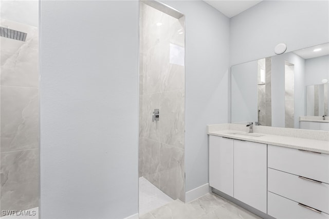 bathroom with marble finish floor, walk in shower, vanity, and baseboards