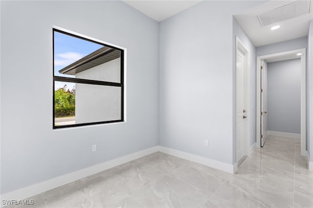 empty room featuring marble finish floor, visible vents, and baseboards