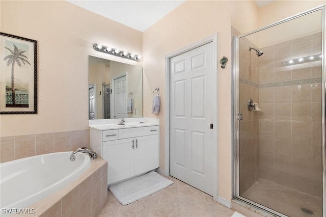 bathroom featuring a stall shower, tile patterned flooring, a garden tub, and vanity