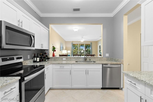 kitchen with stainless steel appliances, ornamental molding, a sink, and white cabinets