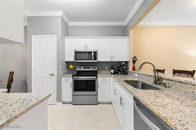 kitchen with stainless steel appliances, ornamental molding, a sink, and white cabinets