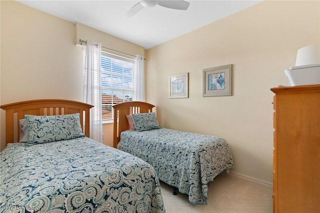 carpeted bedroom with ceiling fan and baseboards