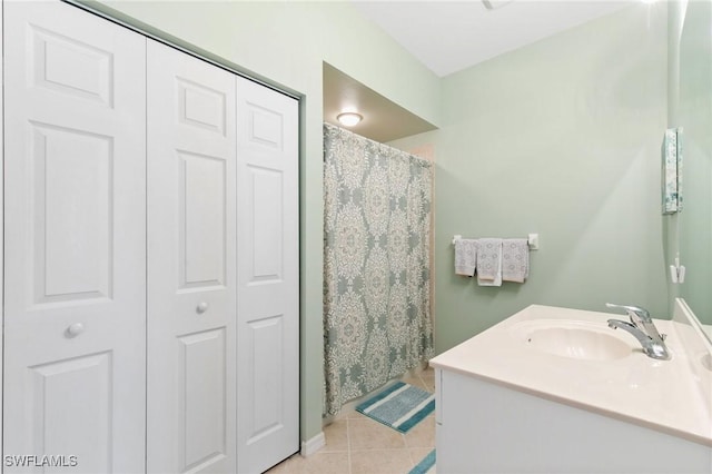 bathroom with tile patterned flooring, a closet, and vanity