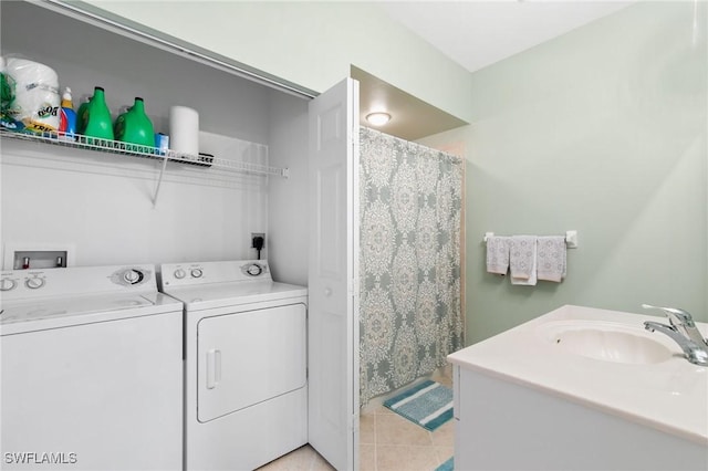 laundry area featuring light tile patterned floors, laundry area, washing machine and dryer, and a sink