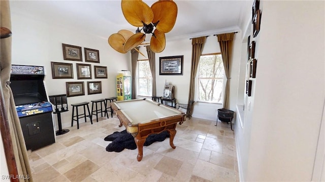 game room featuring stone finish floor, pool table, and crown molding