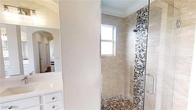 full bath with vanity, crown molding, and a stall shower