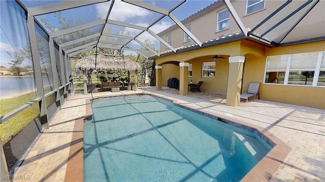 pool with a lanai, ceiling fan, outdoor lounge area, and a patio