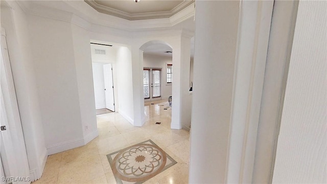 hall featuring visible vents, arched walkways, crown molding, tile patterned flooring, and baseboards