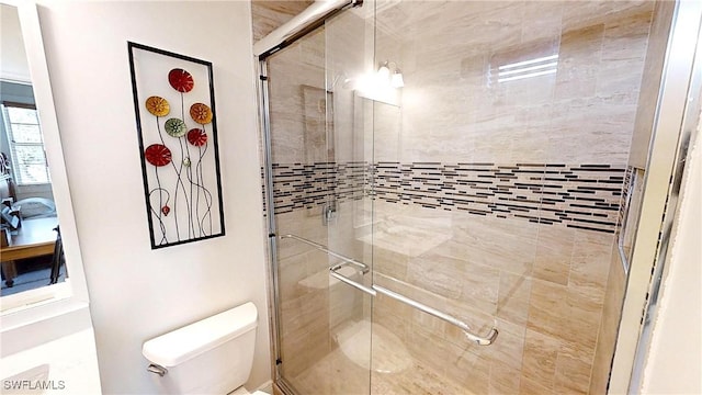 bathroom featuring a shower stall and toilet