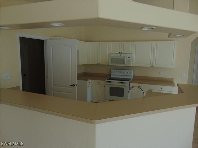 kitchen with white appliances, white cabinetry, light countertops, and a sink